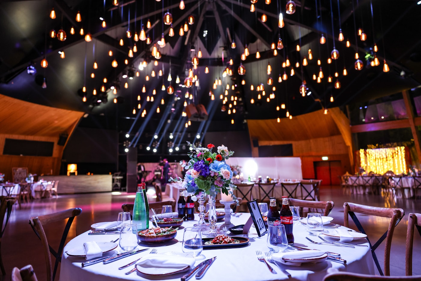 Elegante Eventlocation mit gedeckten Tischen und professioneller Lichtinszenierung