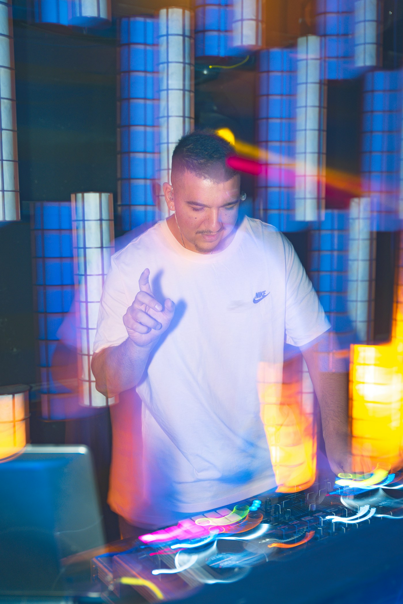 DJ bei einem Clubabend mit blauer und magentafarbener Lichtstimmung